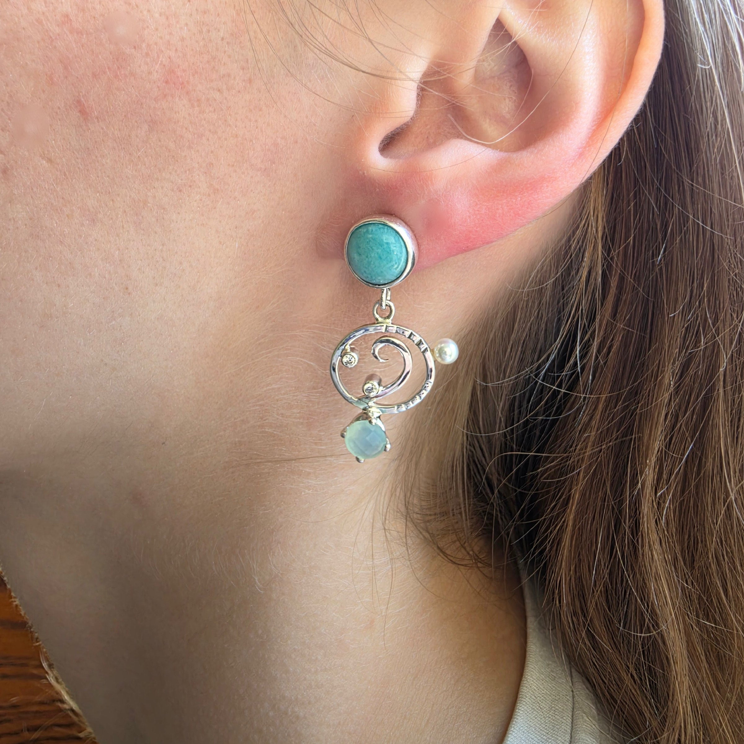 Model wearing Amazonite earrings set in Sterling Silver with Chalcedony, Cubic Zirconia and Freshwater Pearls.