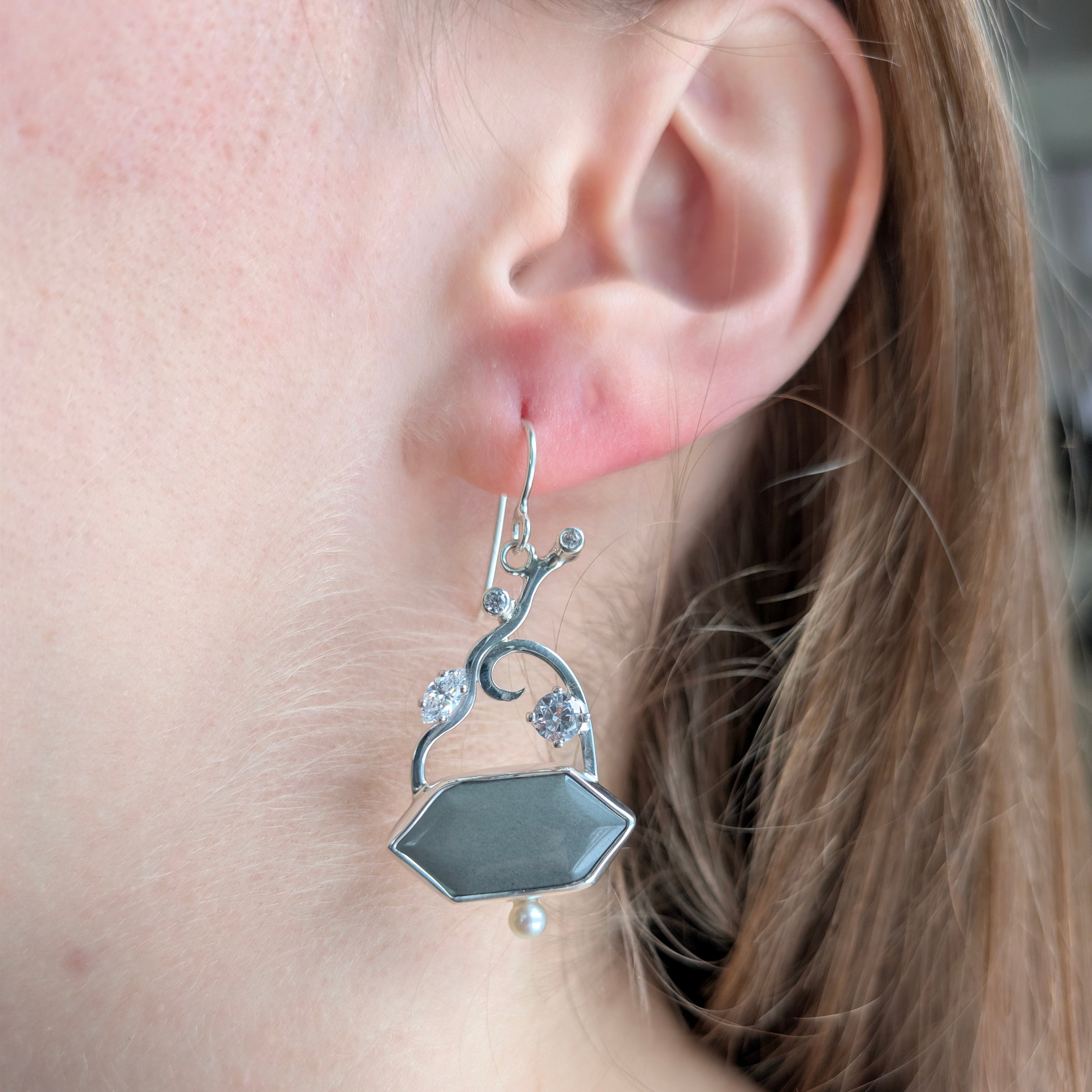 Sterling Silver earrings with Platinum Jasper, Cubic Zirconia and Freshwater Pearls on a model.