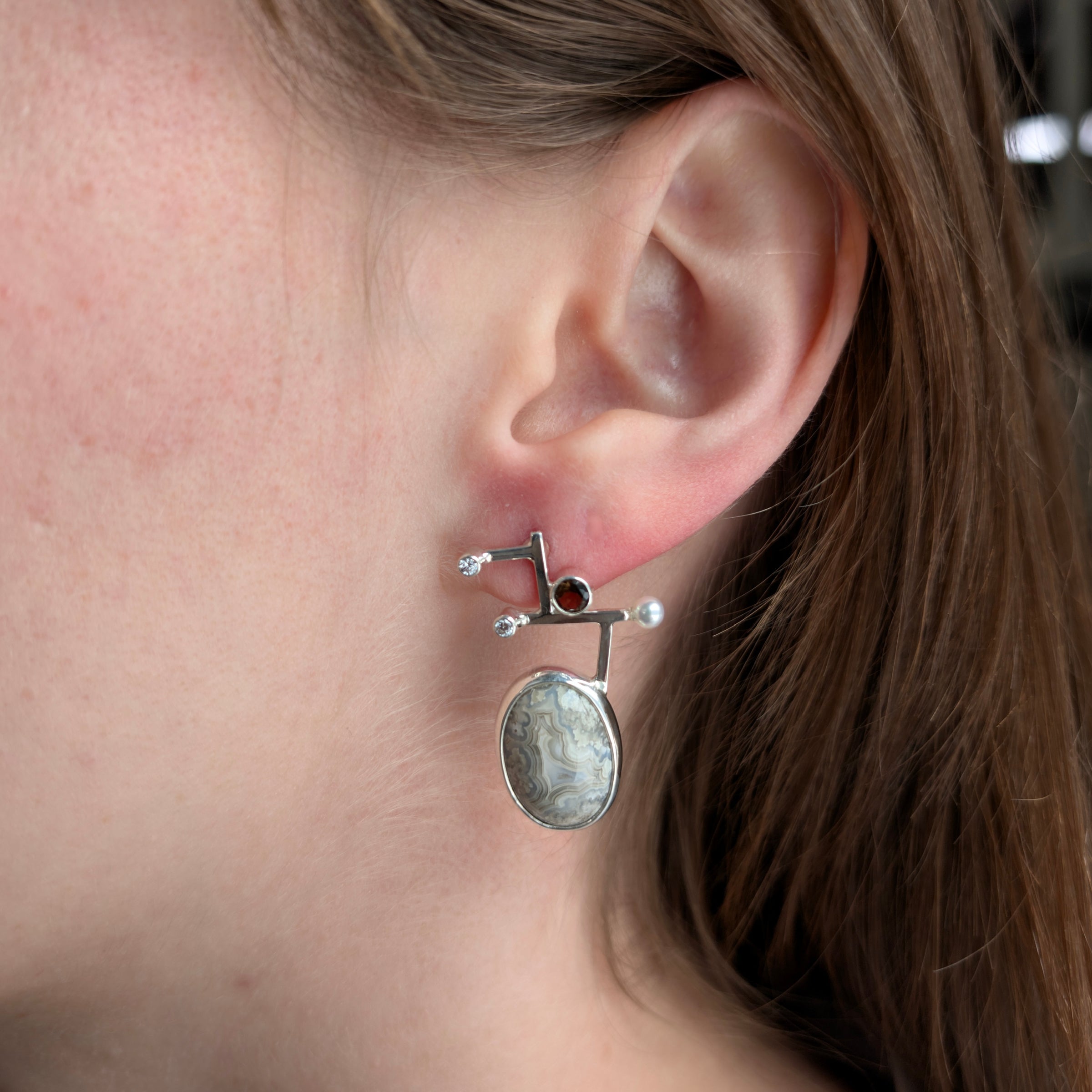 Sterling silver Earrings with Crazy Lace Agate, Smokey Quartz, Cubic Zirconia and Freshwater Pearls on a model.