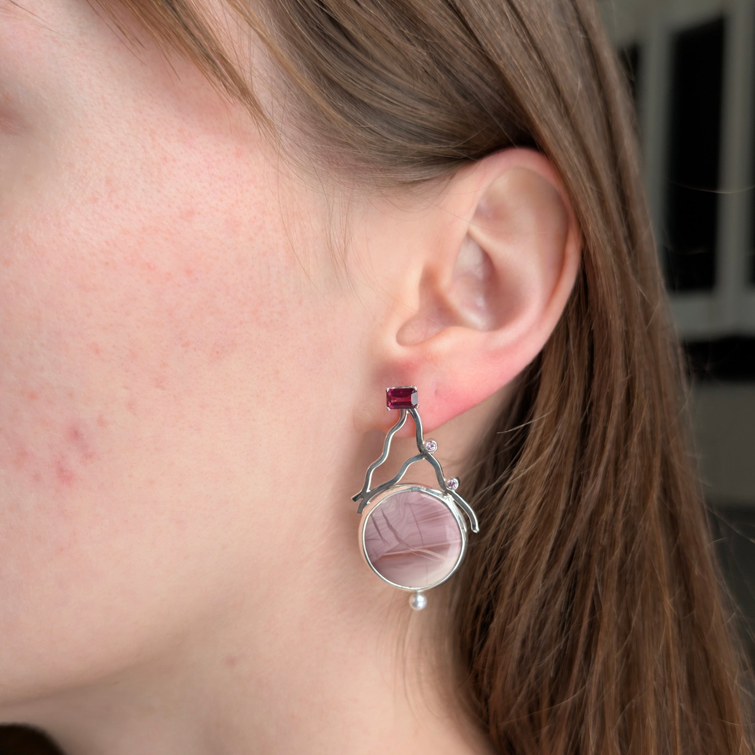 Sterling Silver earrings with Pink Imperial Jasper, Rhodolite Garnet, Pink Cubic Zirconia and Freshwater Pearls on a model.