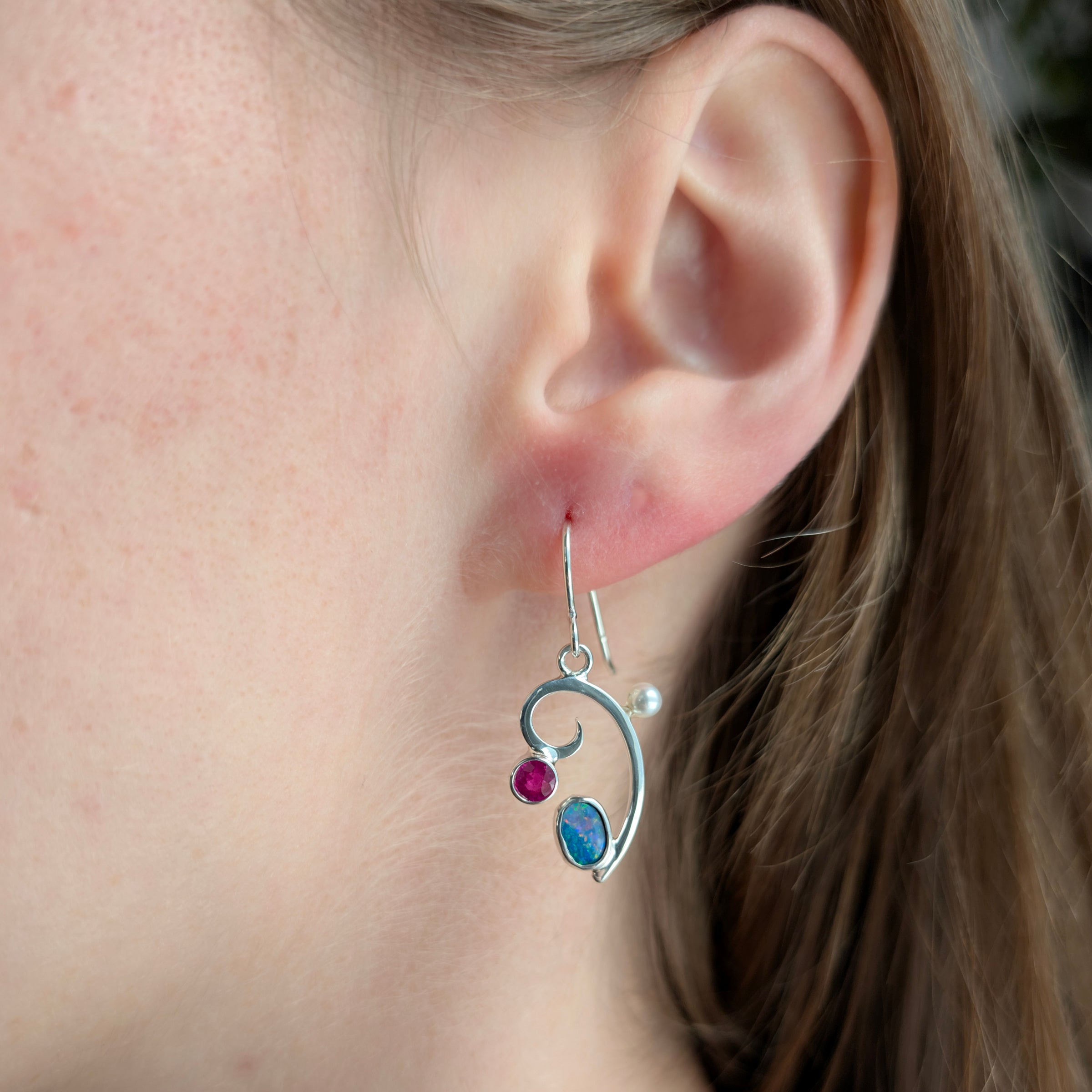 Asymmetric Sterling Silver earrings with Opal doublet, Madagascar Ruby and Freshwater Pearls on a model.