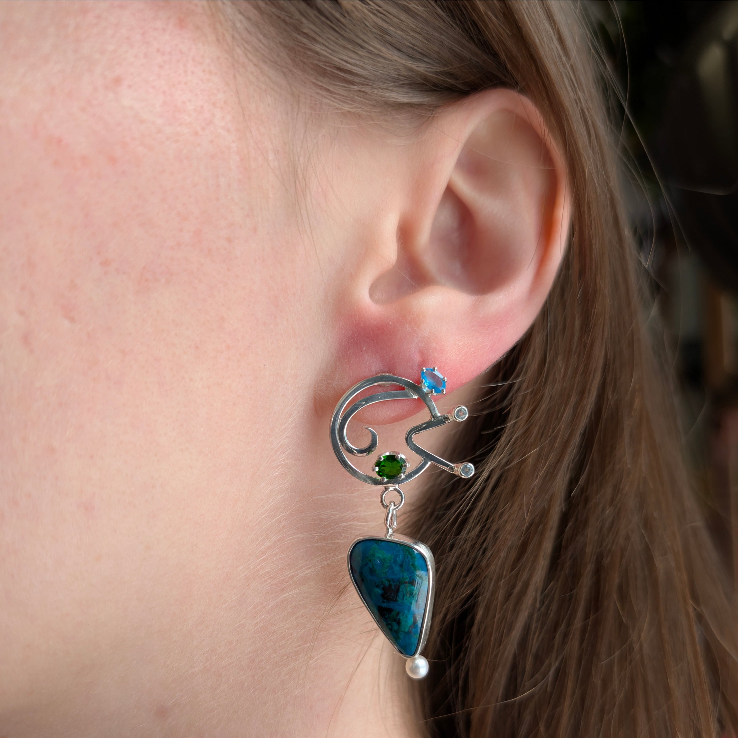 Asymmetric Sterling Silver earrings in Chrysocolla/Malachite, Apatite, Chrome Diopside, Swiss Blue Topaz, Freshwater Pearls on a model.