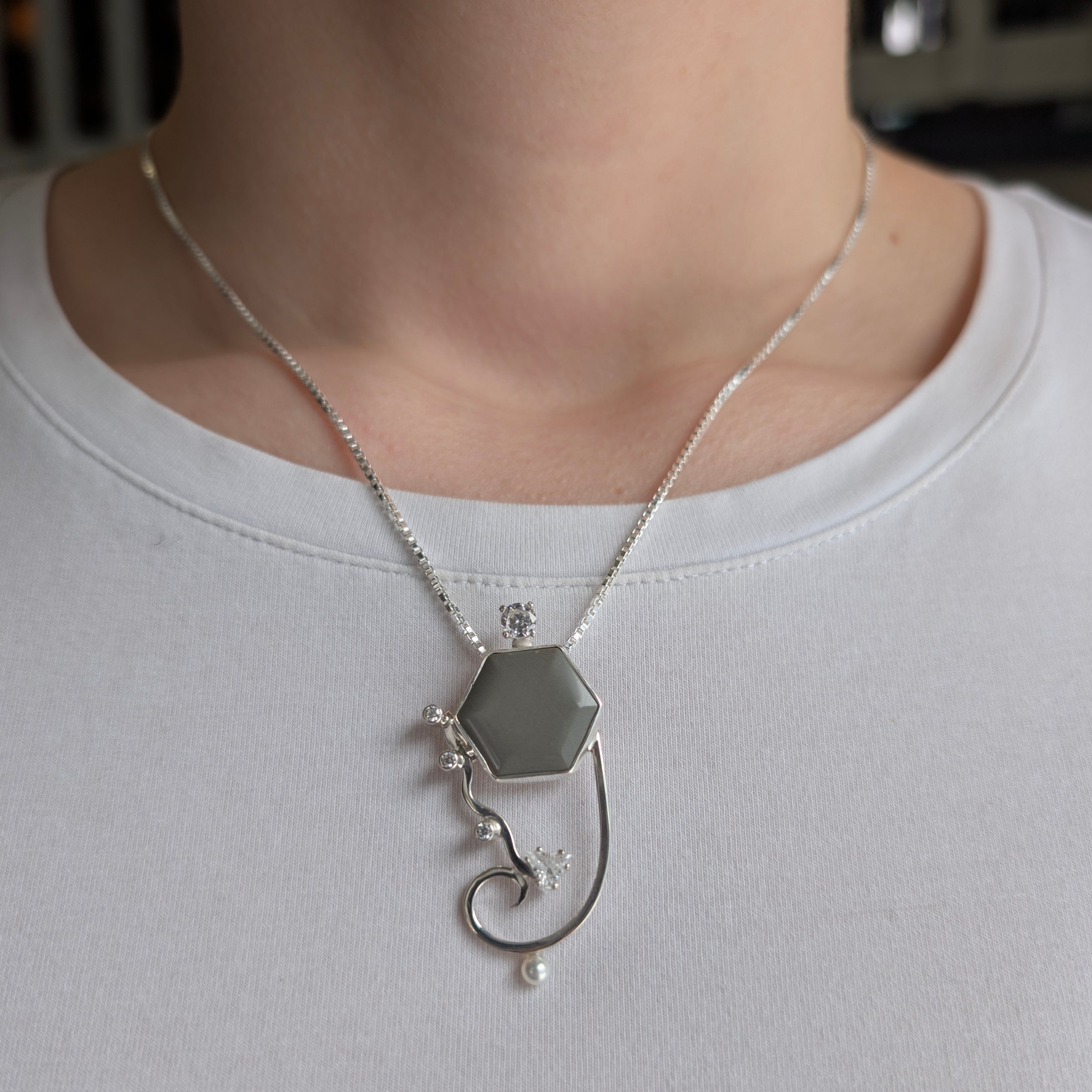Sterling Silver pendant with Platinum Jasper, Cubic Zirconia and Freshwater Pearls, includes an 18 inch Sterling Silver box chain on a model.