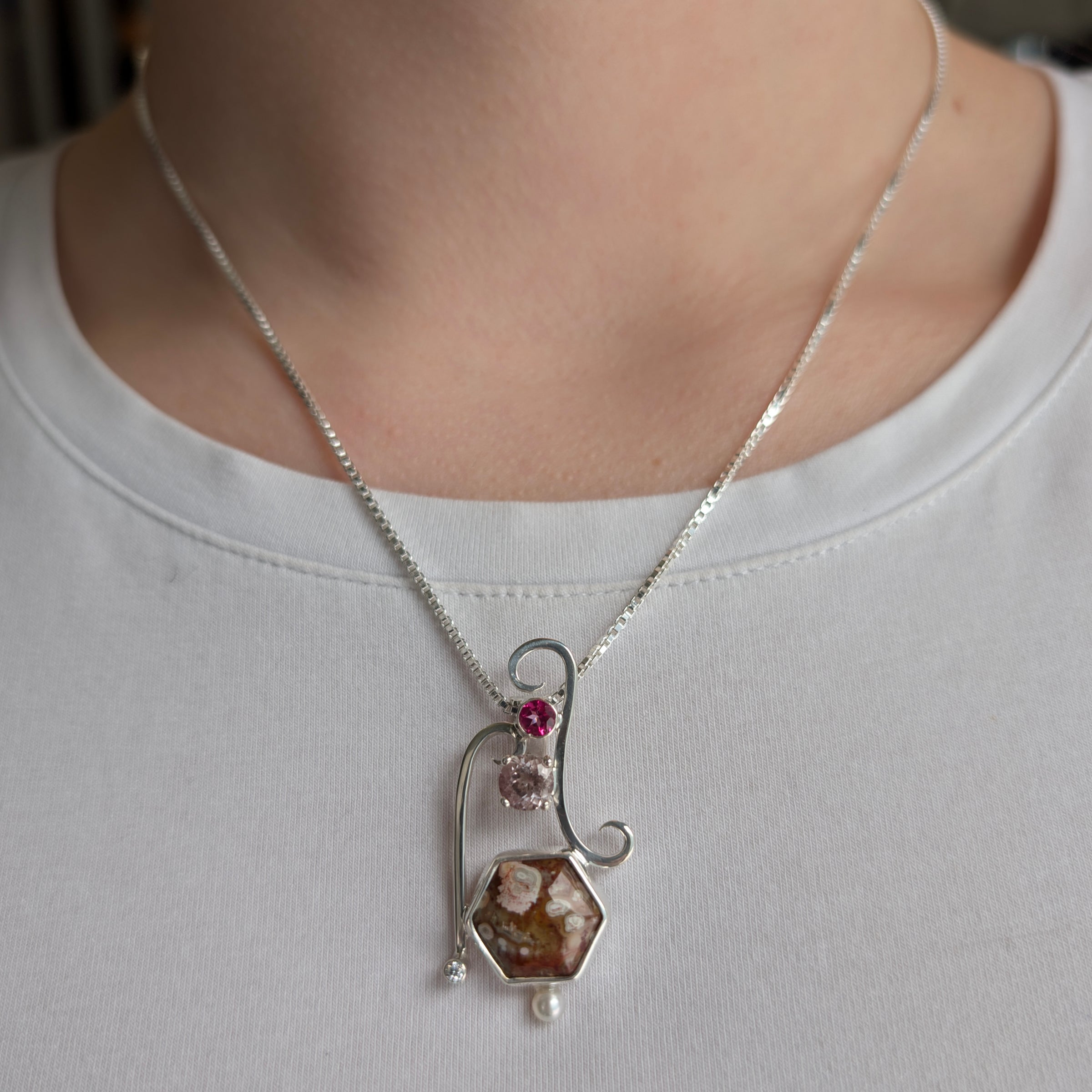 Sterling Silver pendant with Thompsonite, Pink Tourmaline, Pink Topaz, Cubic Zirconia and Freshwater Pearl, includes an 18 inch Sterling Silver box chain on a model.